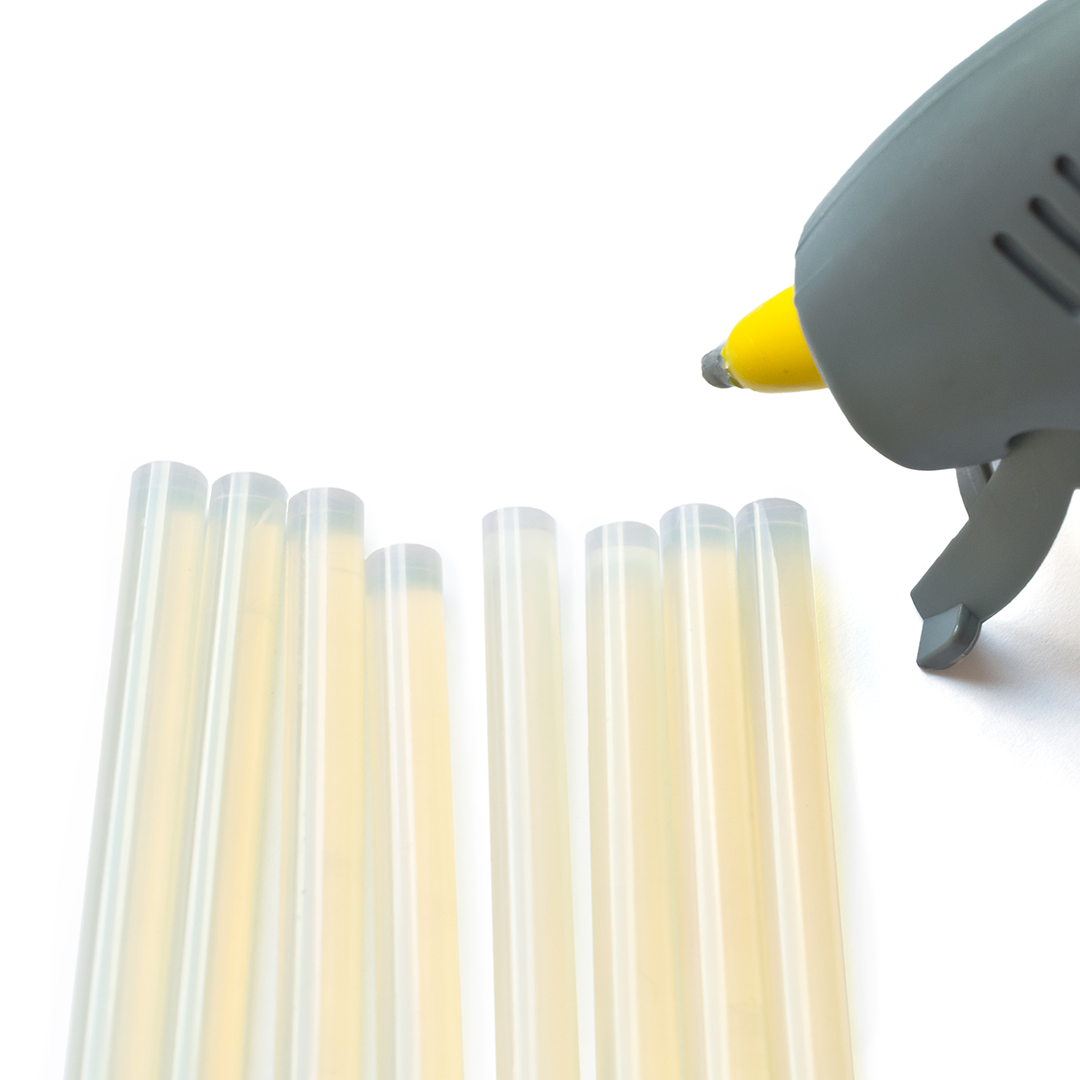 Close up of hot-melt glue sticks and a gluegun.