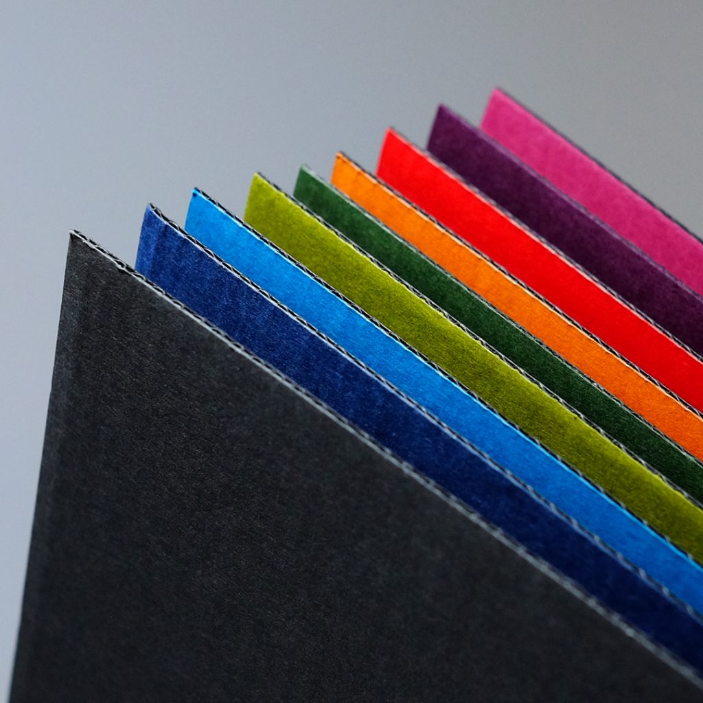 Close up of texture of thin flute corrugated paperboards in various colours.