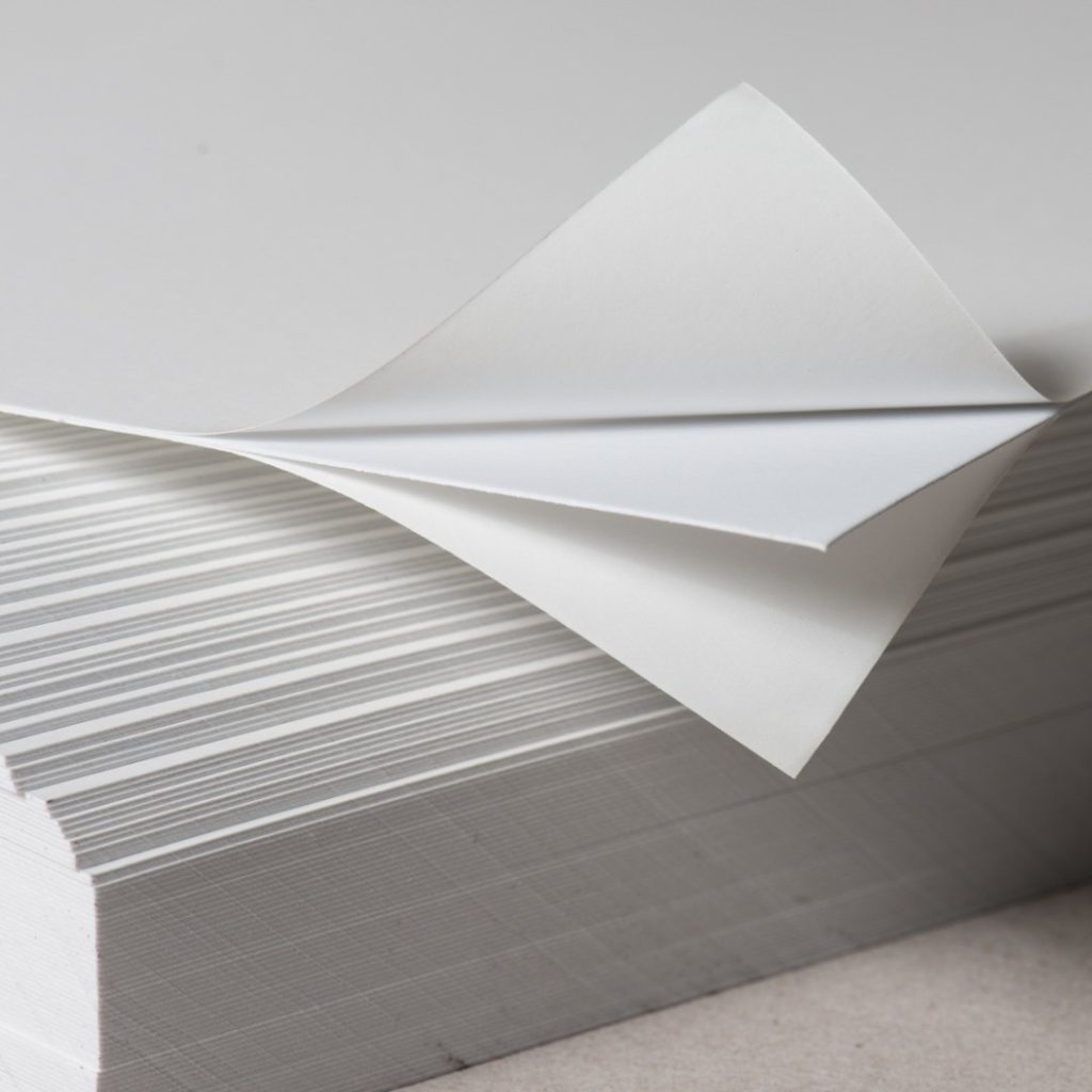 Close up of two-sided self-adhesive white paperboard