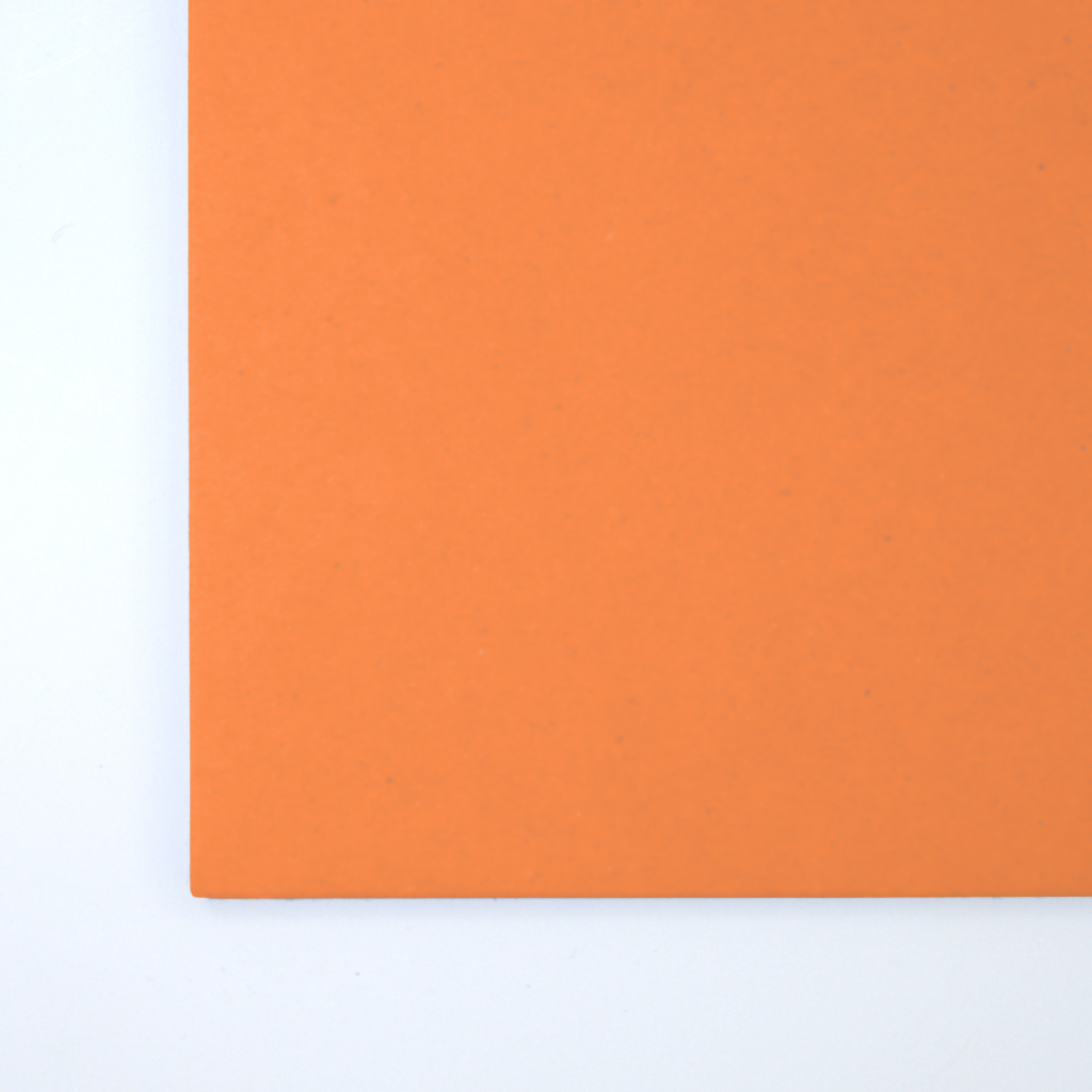 Close up of texture of a solid orange paperboard.