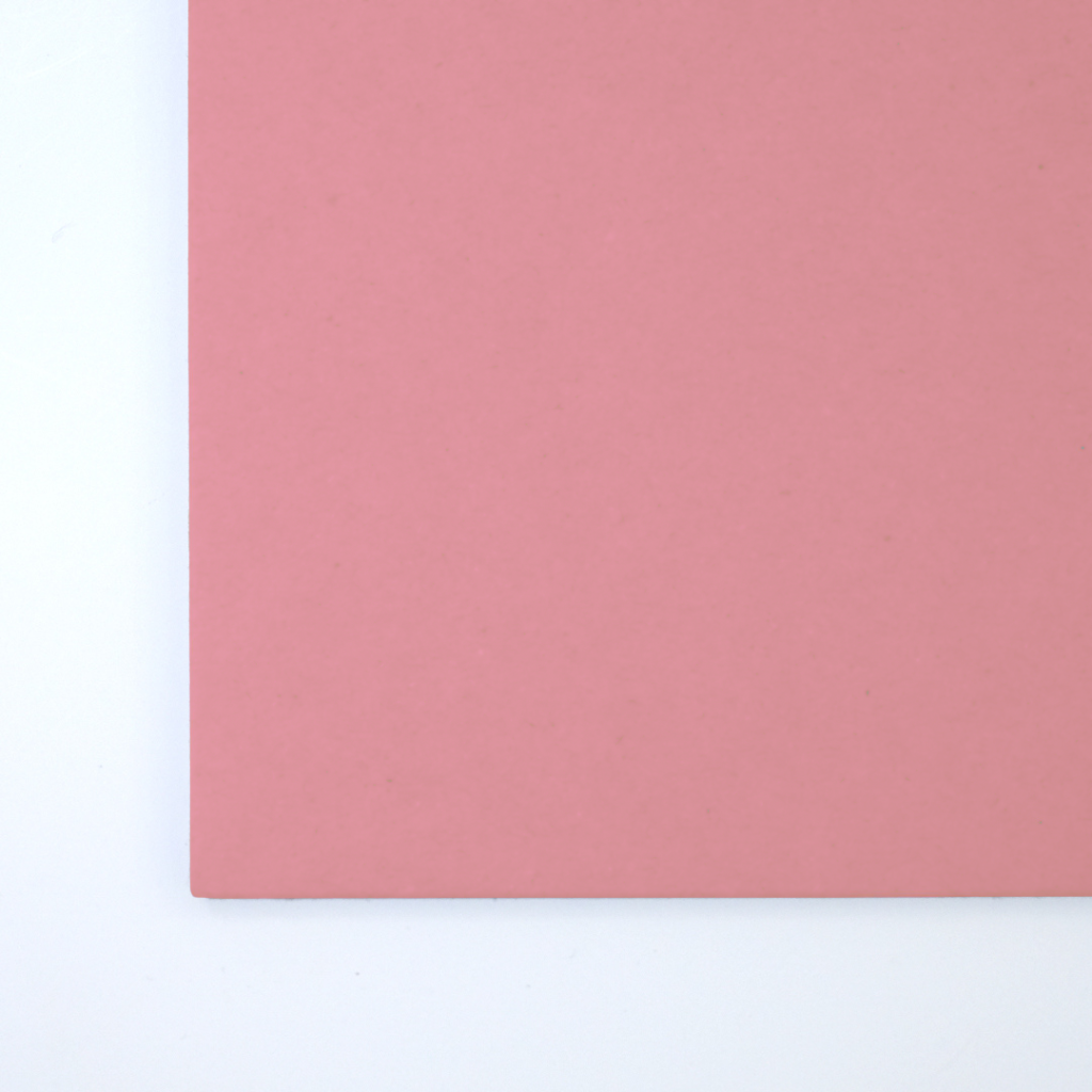 Close up of texture of a solid pink paperboard.